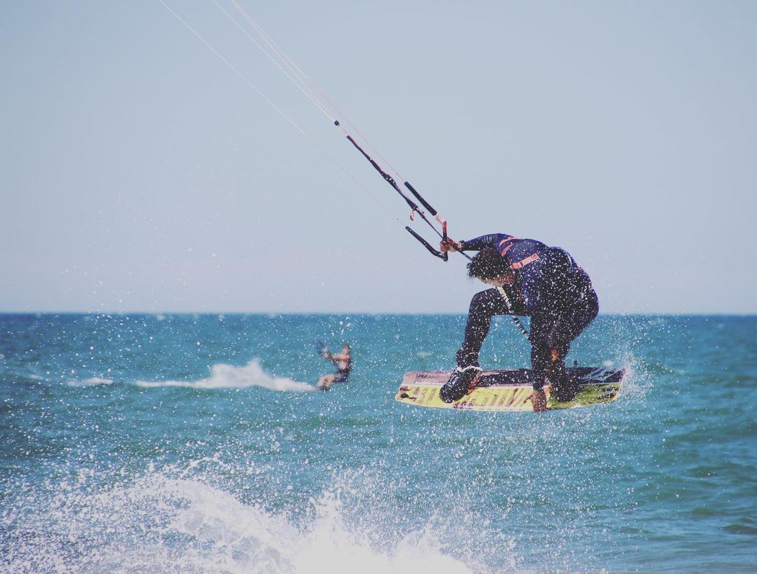 Kitesurfista saltando sobre las olas en la costa de Valencia