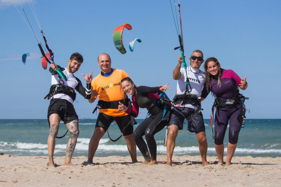 Grupo de alumnos aprendiendo kitesurf en la playa