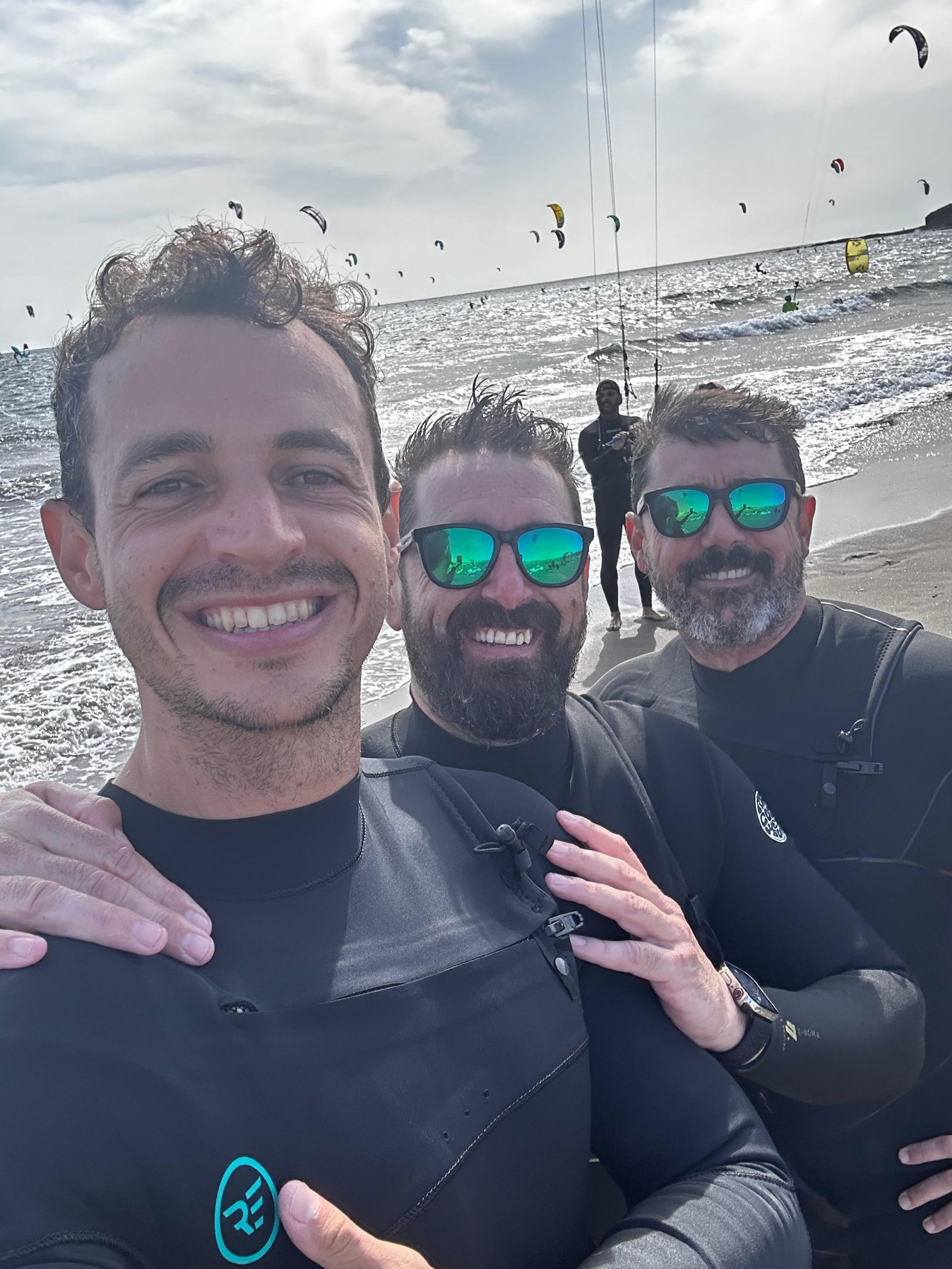 Grupo de kitesurfistas disfrutando en la playa