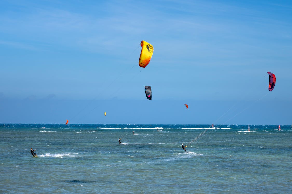 Varios kitesurfers navegando en el mar abierto